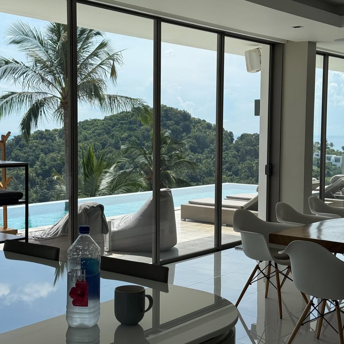 Automatiza tu negocio con Inteligencia Artificial: libera tiempo y aumenta ingresos en piloto automático| BOTMEDIA AGENCY Interior de una habitación luminosa con vistas al océano y palmeras.